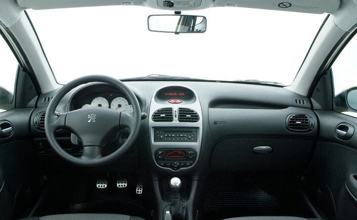 Planche de bord joliment dessinée et agréablement présentée pour la Peugeot 206, mais les plastiques demeurent très ordinaires. Ici en 2003.
