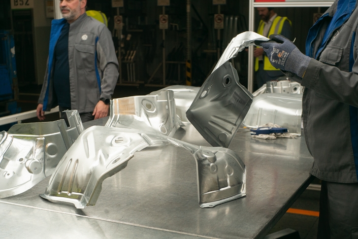 La main de l’homme vérifie la qualité des pièces fabriquées par les machines. Photo Caradisiac.