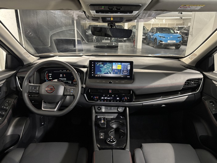 Bienvenue à bord du Nissan X-Trail restylé, qui reçoit un inédit volant à méplat et surpiqûres rouges ici. Comme celle du Qashqai, l’instrumentation intègre une interface Google mais également des applications intégrées dans l’air du temps comme YouTube ou Spotify.