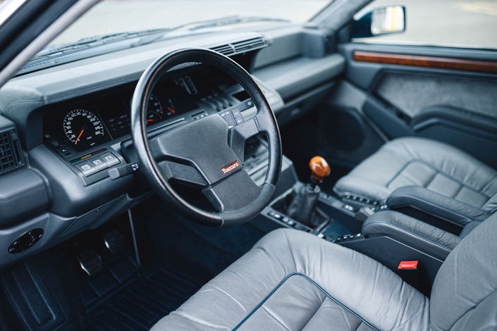 Pierre Bérégovoy profite de l'absence de son garde du corps pour s'asseoir sur le siège avant-droit et subtiliser l'arme de service de ce dernier, dissimulée dans la boîte à gants - Crédit Renault