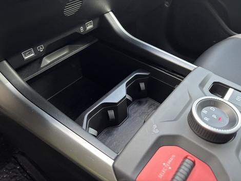 Le Compass propose de nombreux rangements pratiques : ici, un vide-poches complété par un double porte-gobelets et, en enfilade, par un vaste logement placé sous l’accoudoir.