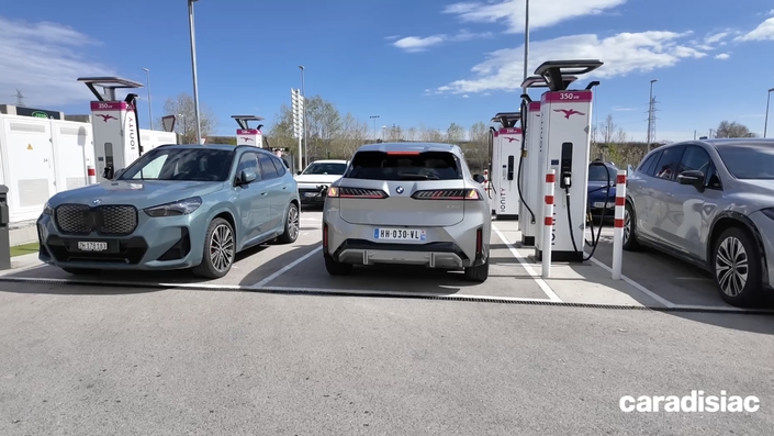 Le iX3 en charge à côté d’un iX1 et d’un Mercedes EQS SUV.