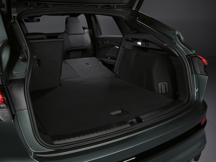 Le hayon électrique de série libère l'accès à un coffre dont le volume s'établit à 515 litres, valeur qui triple quasiment une fois la banquette arrière rabattue (1487 litres). On reste toutefois très loin de la Tesla Model Y (854 litres à l'arrière, en comptant le double fond, à quoi s'ajoutent 117 litres sous le capot). La petite trappe rectangulaire sur la paroi droite abrite une prise électrique.