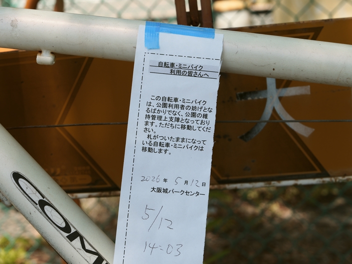 Ce vélo gêne non seulement les usagers du parc, mais constitue également un obstacle à l’entretien et à la gestion du parc. Veuillez le déplacer immédiatement. Les vélos et cyclomoteurs sur lesquels cette étiquette reste apposée seront enlevés. 2 mai 2026 - Centre du parc du château d’Osaka (Osaka-jō Park Center) – 14h03