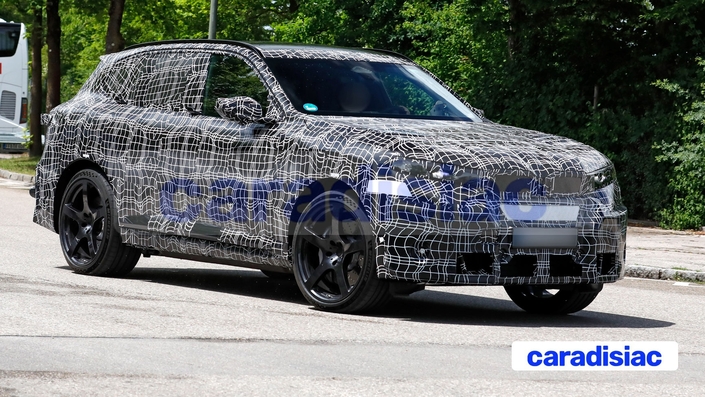 Encore très camouflé, le futur BMW iX5 M laisse apparaître certains éléments de style comme les grandes prises d’air, la calandre pleine, les bas de caisse travaillés et l’on distingue aussi les larges pneus Michelin Pilot S ainsi que le becquet au dessin spécifique qui prolonge le toit.