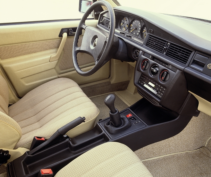 Non, la Mercedes 190 E n'est pas bien équipée d'origine, mais sa finition est remarquable et les aspects pratiques soignés, comme en témoigne le grand vide-poche central.