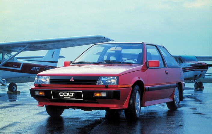 En 1984, la nouvelle Mitsubishi Colt Turbo séduit par son design ultramoderne, ses belles performances et son moteur réussi. Hélas, chère et soumise à des quotas d'importation, on la verra très peu.