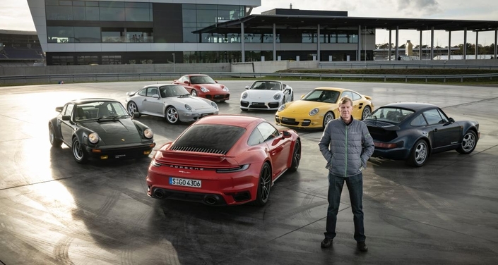 Derrière Walter Rörhl, toutes les générations de la Porsche 911 Turbo : en rouge, la 992.1 de 2020 qui vient d’être remplacée. En vert, la 930 de 1974. En noir, la 964 de 1989. en jaune, la 997 de 2006, en blanc, la 991 de 2013, en gris la 993 de 1995 et en rouge, la 996 de 2000.
