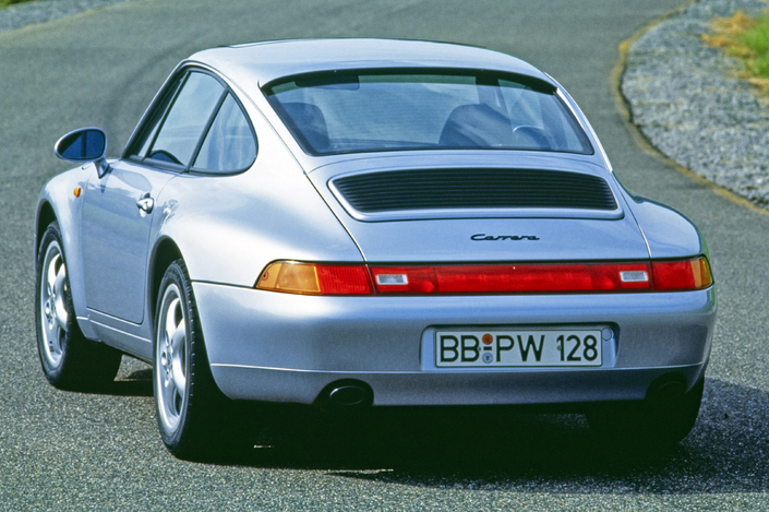 La Porsche 993 exhibe une poupe totalement modelée face à celle de la 964, et des voies élargies. Mais elle conserve le bandeau rouge entre les feux.