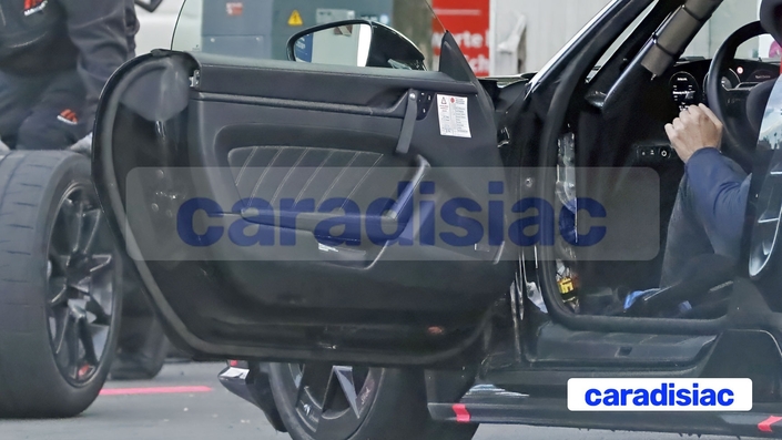 L’ouverture de la portière côté conducteur ne permet pas encore de savoir à quoi ressemble l’habitacle de la Porsche Boxster Électrique. Une auto « découvrable » qui conserve la capote souple de l’actuelle génération.