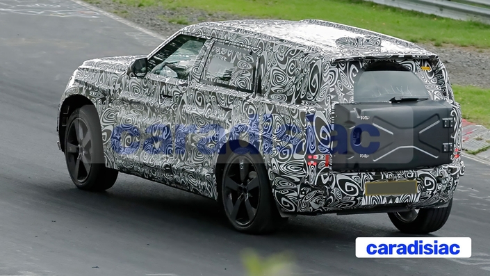 Ce drôle de boîtier sur la porte du coffre du Land Rover « baby » Defender pourrait, selon nos chasseurs de scoop, recevoir les câbles de recharge de ce modèle électrique. Le boîtier positionné sur ce prototype n’est pas encore le modèle définitif qui pourrait être proposé en option avec le modèle de série du « baby » Defender.