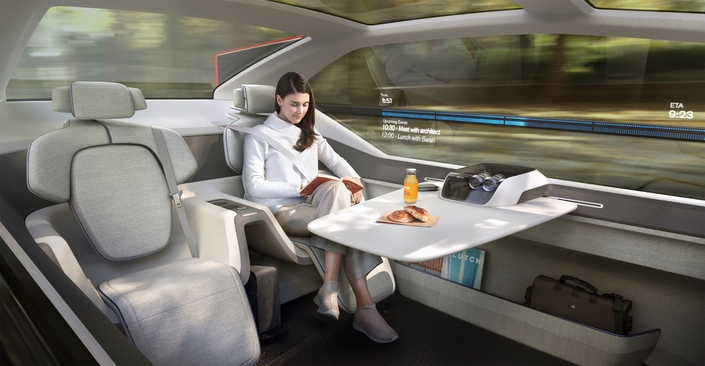 une conductrice qui déjeune à bord de la voiture qu'elle "conduit", comme ce concept car Volvo n'est pas pour demain.