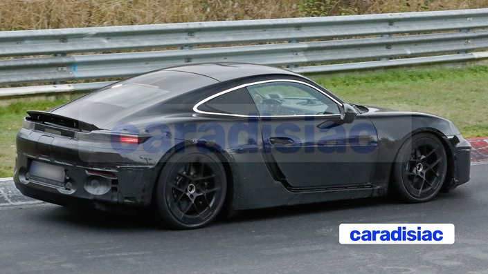 Malgré l’adhésif blanc qui essaie de nous tromper, on voit clairement sur cette photo le nouveau dessin de la vitre de custode de la Porsche Cayman électrique. On découvre aussi sur ce prototype, le design de la lunette arrière ainsi que la nouvelle signature lumineuse des feux. Il ne reste plus qu’à découvrir le modèle de série de cette auto qui sera dévoilé dans le courant de l’année prochaine.