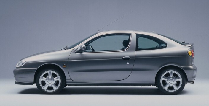 En coupé, la Renault Mégane raccourcit son empattement face à la berline, ce qui donne une ligne trappue et pleine de caractère. En 2.0 16v, les jantes atteignent 16 pouces, un diamètre inusité pour une compacte en 1995.