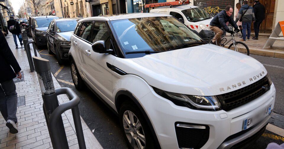 SUV squeezed into a tight urban parking space